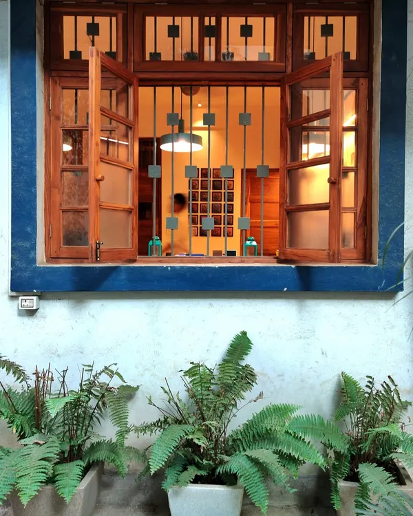 A view into our studio from the outside, framed by the original 60-year-old windows. This space is Nikita's family home, and we've taken great care to preserve its heritage, from the terrazzo floors to the intricate grill work.