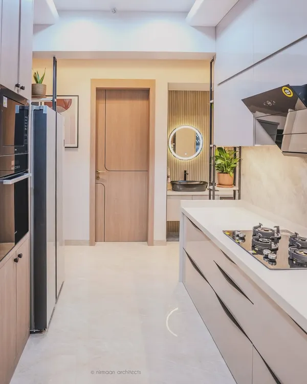 This sleek, modern kitchen at Sai World Empire features handleless cabinets and a clean, linear design. The layout provides a clear view into the wash area, which is designed with the same level of detail.