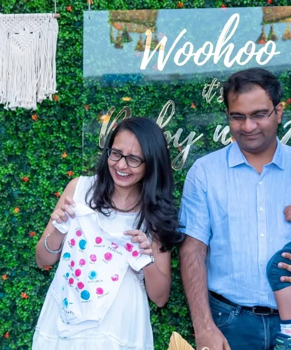 A candid moment of laughter at a baby shower as the parents-to-be look at a tiny baby outfit. These are the genuine, happy moments we strive to capture for you.