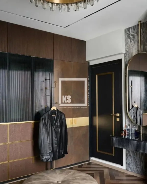This custom wardrobe and vanity area shows how I blend different textures and finishes. Notice the combination of dark wood, ribbed glass on the vanity, textured laminate on the drawers, and brushed gold accents for a look of quiet luxury.