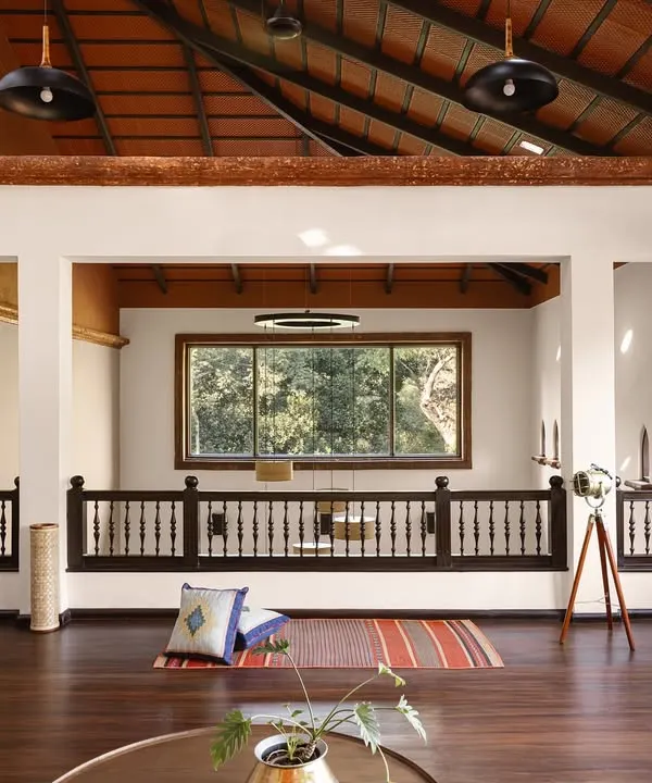 The wooden mezzanine lounge is a perch in the sky, offering a meditative seat to watch the seasons turn. The soaring terracotta-tiled roof and hand-turned balustrades frame the forest view, making the landscape a living part of the room.