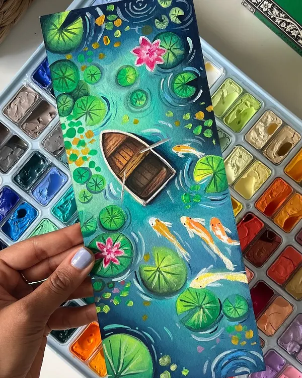 This gouache painting of a boat drifting in a lily pond is one of my favorites. I used layers of rich greens and blues to create a sense of depth and peace, with koi fish swimming just beneath the surface.