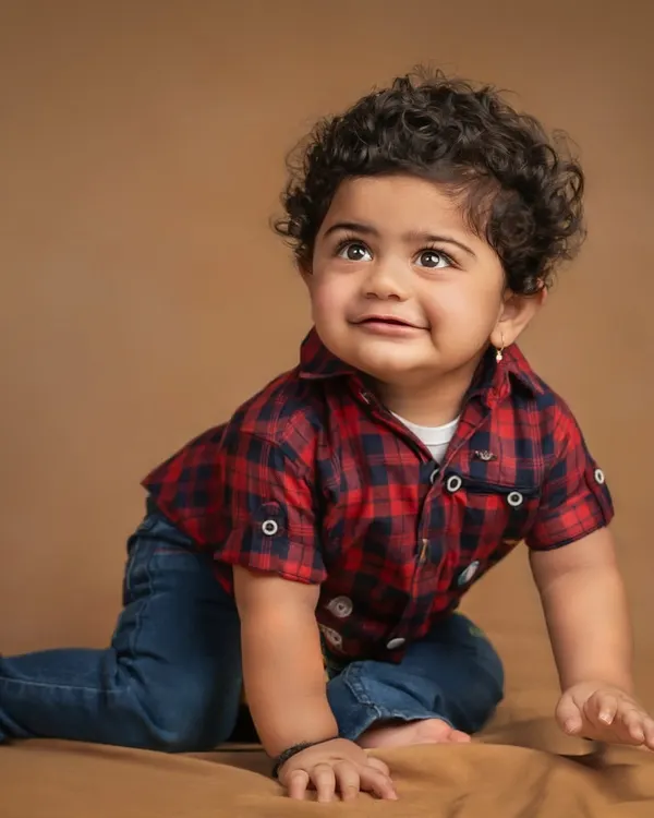 That curious, upward glance is so precious. This sitter session captures the personality of a baby boy in his cute plaid shirt as he explores the studio.