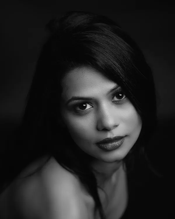 An intense and direct black and white headshot. I used a single light source to create this high-contrast, chiaroscuro effect, drawing all attention to the subject's powerful gaze.