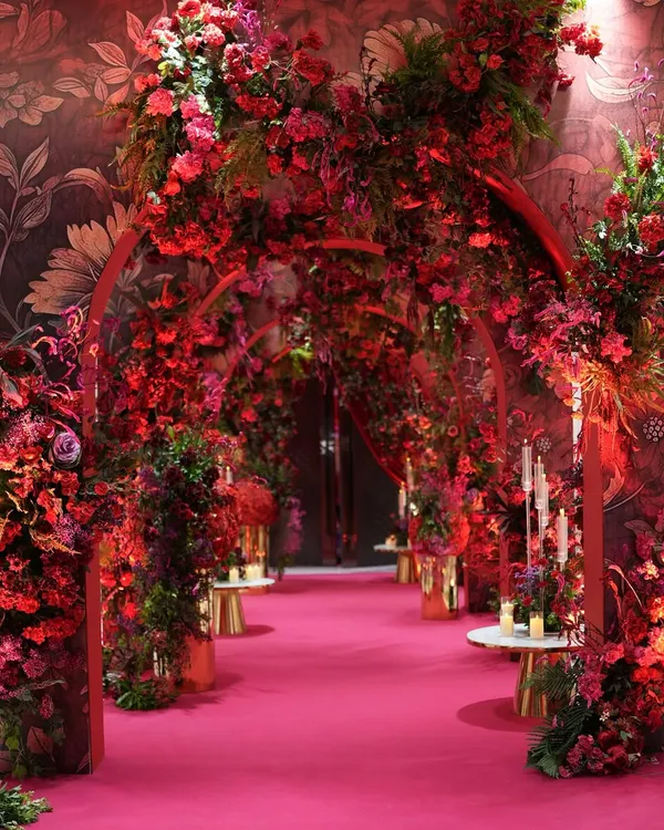 This red entrance is not just a doorway; it is a statement. I designed this grand, immersive experience with layered arches of red flowers to make a first impression that lingers, a warm embrace wrapped in shades of passion.