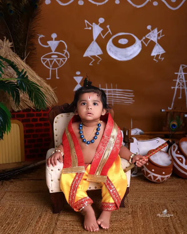 Your little one as the divine Bal Gopal. This Janmashtami setup features a traditional Warli art backdrop and a miniature throne, creating an authentic and charming portrait.