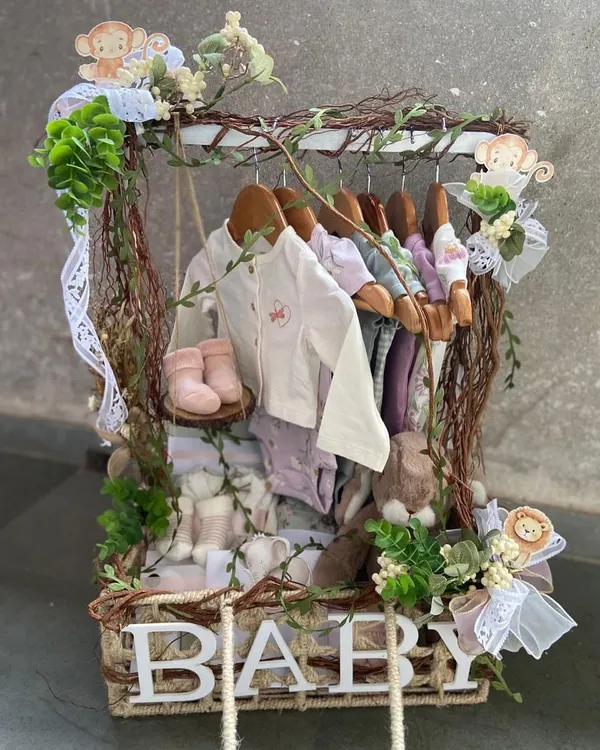 Our signature baby clothes hamper, creatively designed to resemble a miniature closet. This jungle-themed version features tiny hangers with baby outfits, booties, and plush toys, all nestled in a rustic, vine-adorned basket.