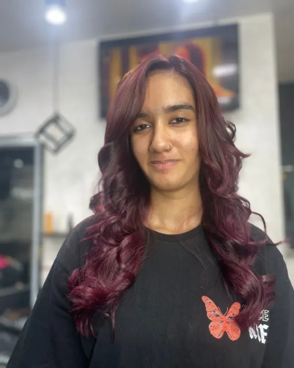 A beautiful example of a rich, wine-red hair color. The soft curls enhance the multi-tonal quality of the shade, showing off deep cherry and burgundy notes.