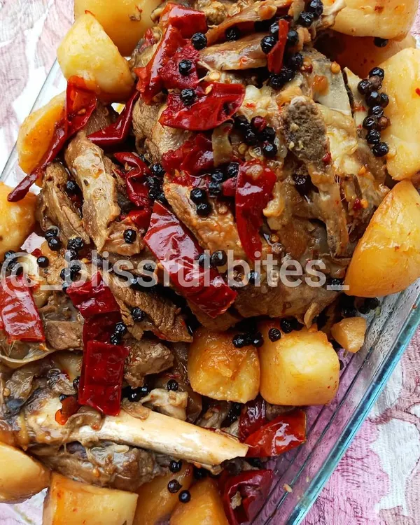 My Lamb Roast is a complete meal, featuring tender, bone-in lamb and soft potatoes roasted together. The meat is coated in a thick masala and garnished with whole red chilies and black peppercorns for a bold, aromatic flavor.