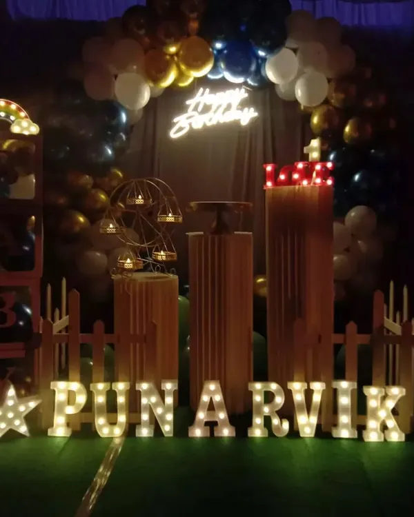 This setup shows how props can create a complete theme. I used marquee letters for the name "PUNARVIK", a light-up star, a picket fence, and "BABY" display boxes to build a charming scene for a first birthday.