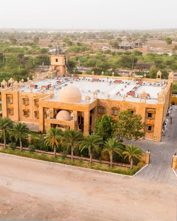 An aerial drone shot of the magnificent Chokhi Dhani Palace Hotel in Jaisalmer, showcasing the grand scale of a desert destination wedding.