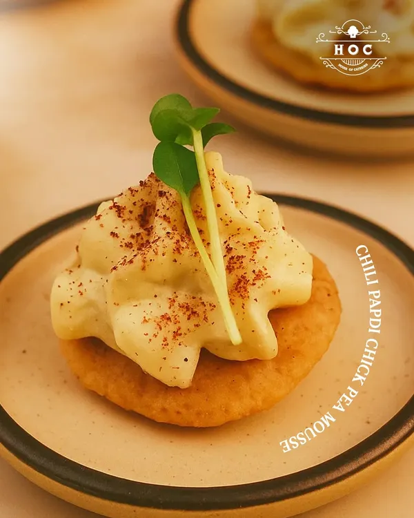 A perfect fusion of textures and tastes. Our Chilli Papdi with Chickpea Mousse is a signature creation, offering a modern gourmet twist on a traditional Indian cracker.