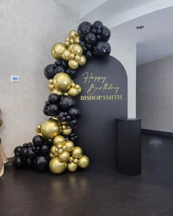 This is a clean and professional birthday decoration I did for a corporate executive. The setup includes a custom arched backdrop with personalized text and an elegant balloon garland in matte black and chrome gold.