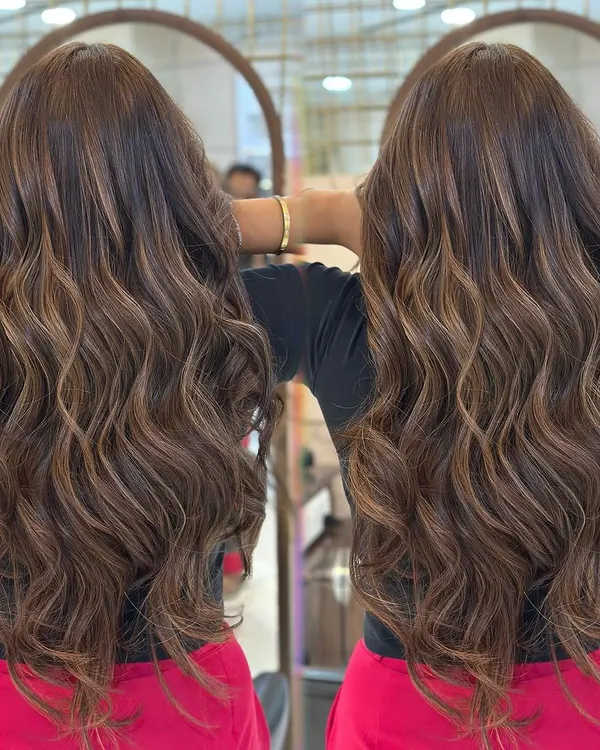 A perfect example of our hot mocha brown French balayage. Notice how the highlights are seamlessly blended to create a rich, dimensional effect with beautiful, wavy styling.