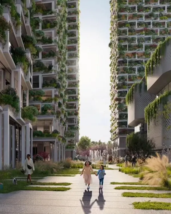 The central pedestrian spine of the Sky Gardens project in Hyderabad, flanked by towers with lush green facades. This space is designed as a vibrant community hub, promoting walkability and social interaction.