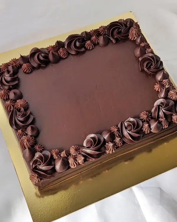 Sheet cakes are the perfect solution for serving a crowd. This is a classic dark chocolate sheet cake with a beautifully piped border, ready to be customized with a message or served as is for a simple, delicious treat.