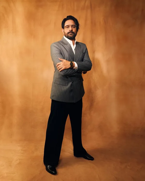 A full-length shot of Jaideep Ahlawat looking sharp in his award-winning suit. The double-breasted cut and wide-leg trousers are a modern take on classic tailoring.