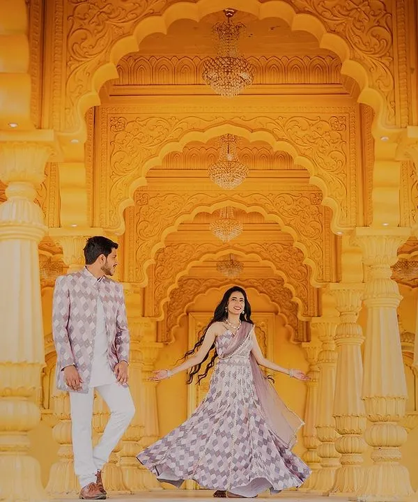 A fairytale moment in a grand, palace-like setting. The stunning yellow architecture and her twirling lehenga create a scene of pure elegance and romance at Sets in the City.