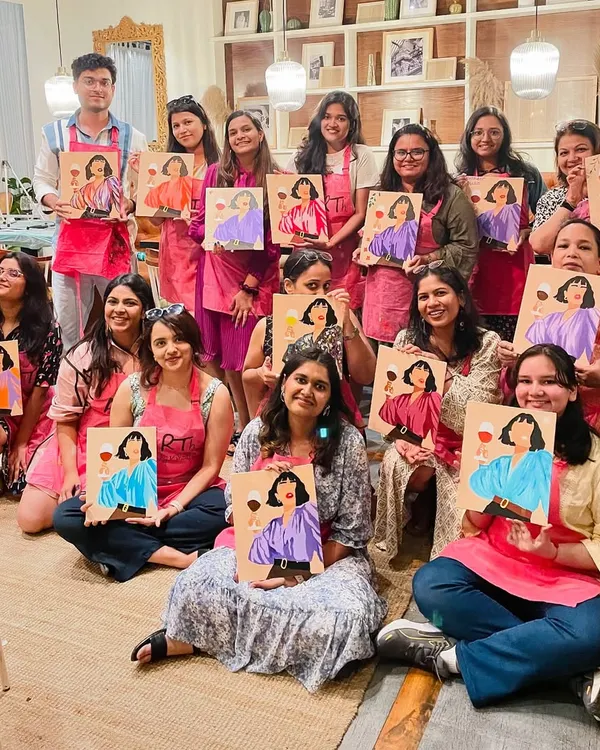 A large, happy group from a wine and paint workshop. These public sessions at cafes are a great way to meet new people and spend an afternoon creating together.