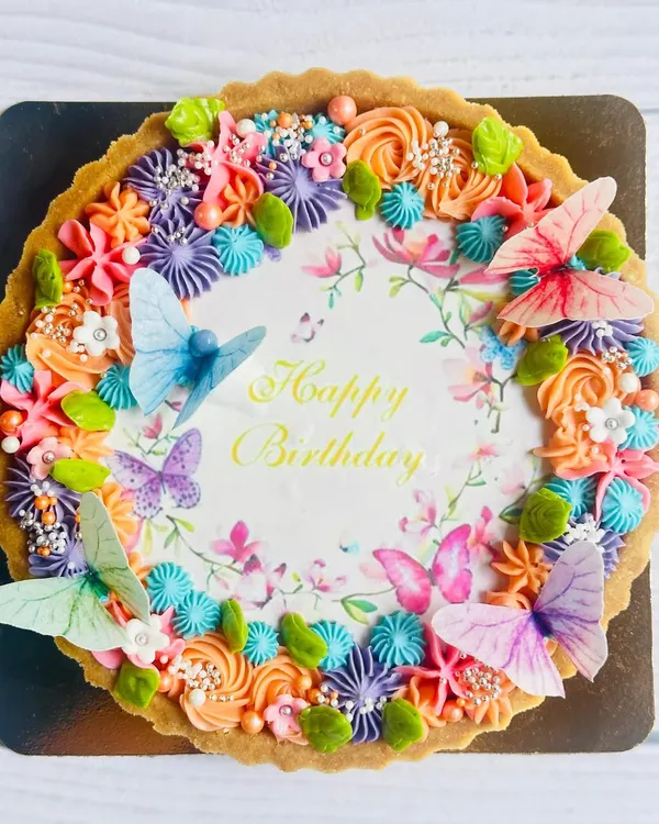 This is what pure joy looks like in a tart. My custom birthday tarts are a canvas for celebration, featuring a rich chocolate base, vibrant buttercream flowers, and delicate edible butterflies to make any birthday unforgettable.