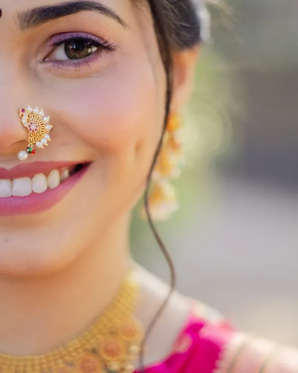 The joy on a bride's face is everything. This close-up captures the essence of a traditional Maharashtrian look, with a delicate Chandrakor bindi, a classic Nath, and makeup that enhances her natural radiance.