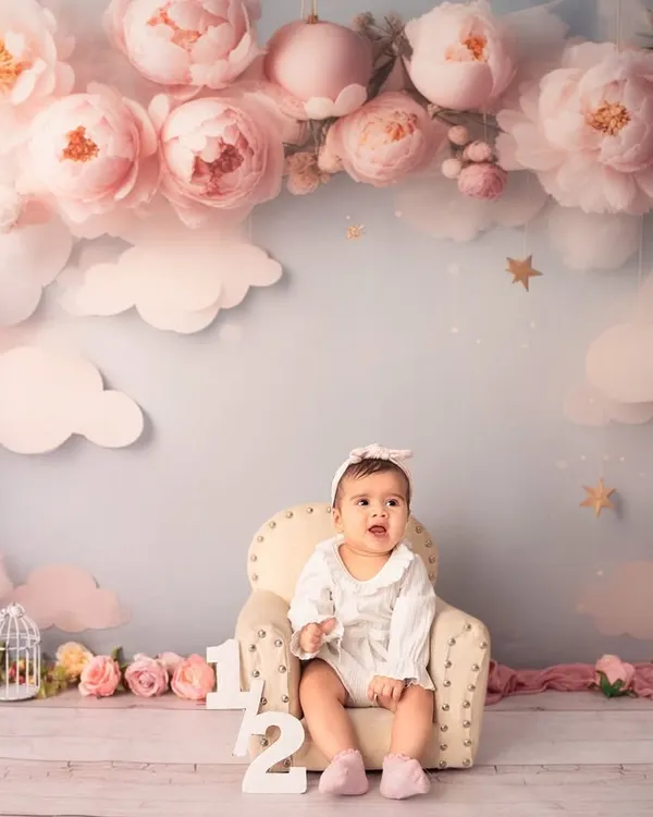 A floral fantasy for a six-month milestone. This dreamy setup with pink peonies and fluffy clouds is perfect for celebrating your little one sitting up on their own.