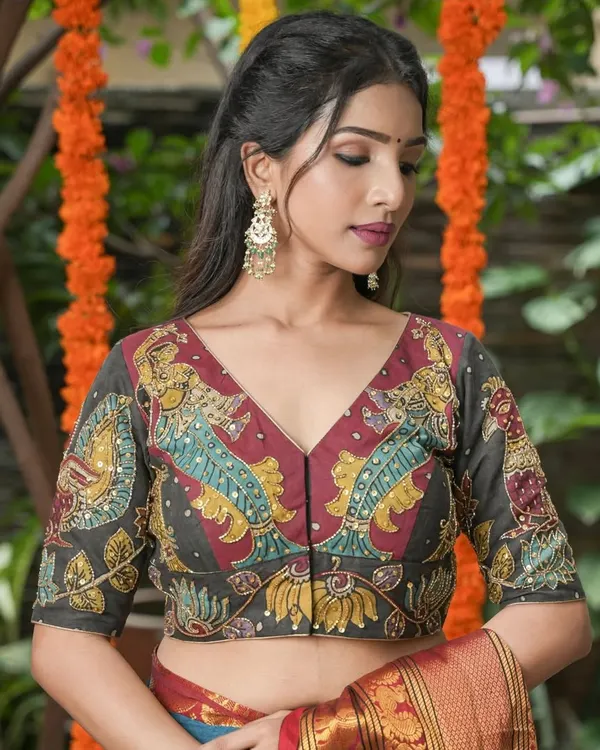 This V-neck blouse showcases a detailed Kalamkari fish motif, a symbol of prosperity and abundance. The artwork is highlighted with subtle sequin embellishments, adding a touch of sparkle to the traditional design.