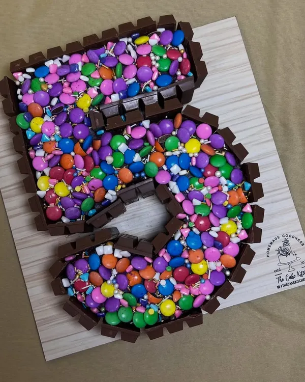 This number "5" cake is a chocolate lover's dream. It's framed with KitKat bars and filled to the brim with colorful Cadbury Gems.