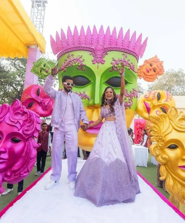 When love takes center stage, the world becomes a carnival. This couple's entry was a burst of joy, with colorful masks and entertainers creating a festive, playful atmosphere.