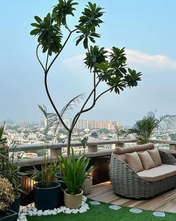 We designed this luxurious rooftop terrace to be a true urban sanctuary. It features a combination of wooden decking, artificial grass, curated planters, and comfortable wicker furniture, all overlooking the city skyline.