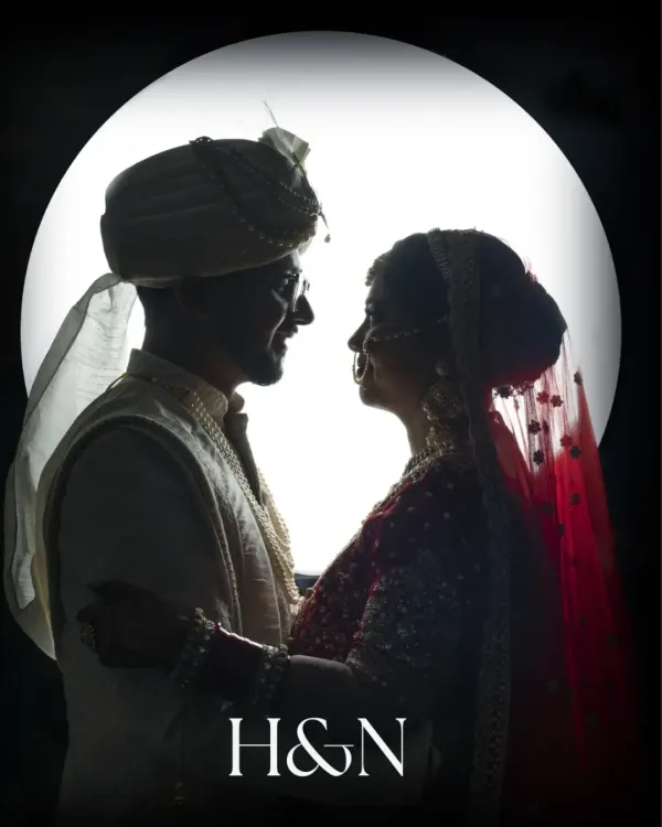 A dramatic silhouette of the bride and groom against a full moon, a creative and timeless wedding portrait.