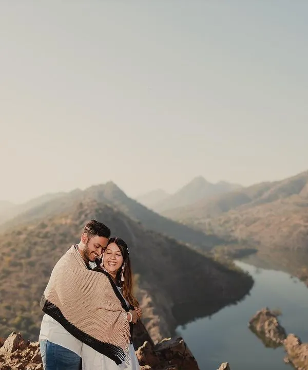There's nothing like the quiet of the mountains at sunrise. Wrapped in a blanket against the morning chill, this couple shared a beautiful moment overlooking the serene lakes of Rajasthan.