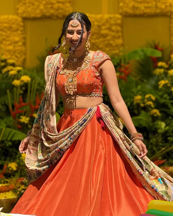 This bride is glowing in a custom orange silk lehenga. The skirt features a hand-painted border, and I paired it with a fully Kashmiri embroidered georgette dupatta and a matching embroidered blouse for a vibrant, celebratory look.