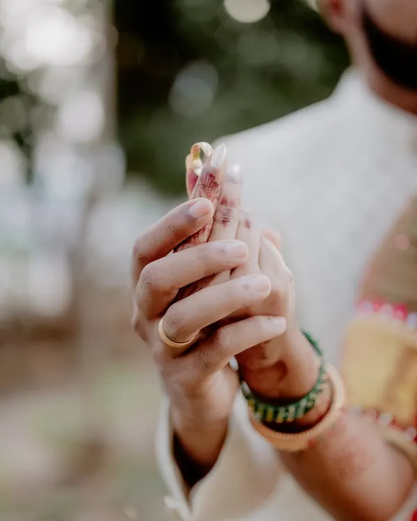 The moment forever begins. This close-up on the ring exchange is tightly framed to capture the intimacy and significance of the promise being made.