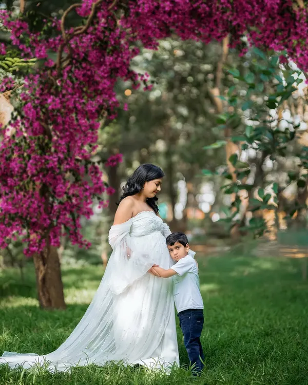 A precious moment between a mother and her son, who is lovingly hugging his new sibling through the baby bump. This is what family love looks like.