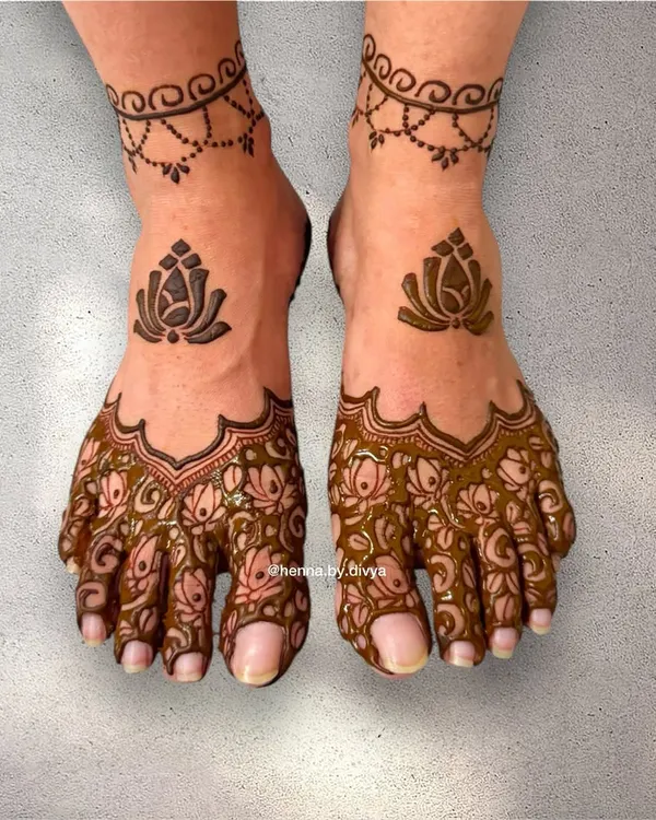A lovely lotus-themed design for the feet. This pattern covers the toes with intricate floral work and features a larger lotus motif on top, connected to a simple ankle cuff.