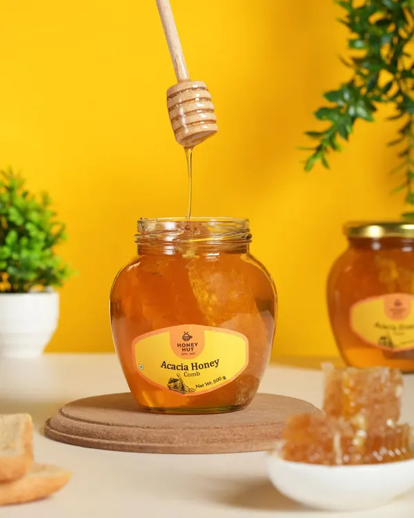 An action shot of honey being drizzled from a dipper. Capturing motion like this adds a dynamic and delicious element to product photography, perfect for showing the product's texture.