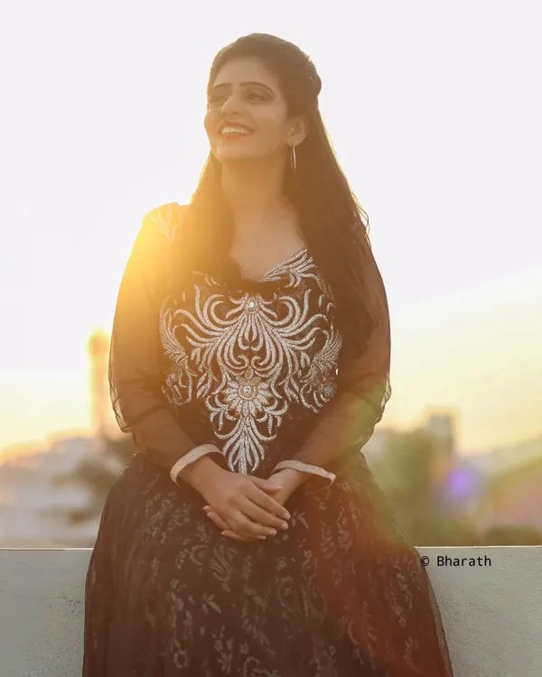 A beautiful rooftop portrait taken during the golden hour. The setting sun creates a stunning flare and a warm, magical light.