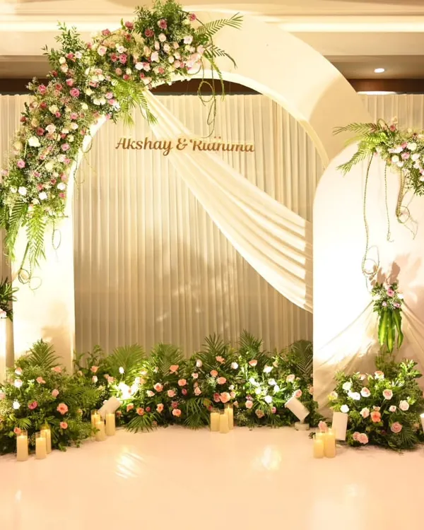 A dreamy floral arch in pastel pinks and whites creates the perfect backdrop for a Roka ceremony. The soft draping and warm candlelight add to the romantic ambiance.
