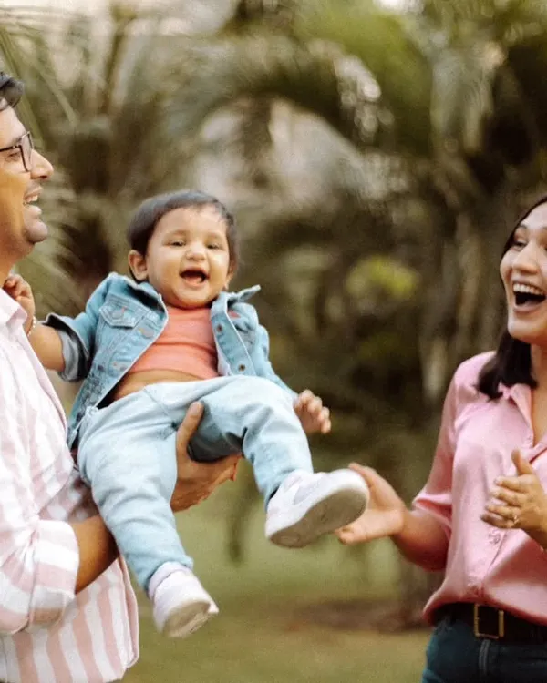 A candid moment of pure joy during an outdoor family session in Delhi. We love capturing these unposed laughs as parents play with their child, creating memories that feel as happy as the day itself.