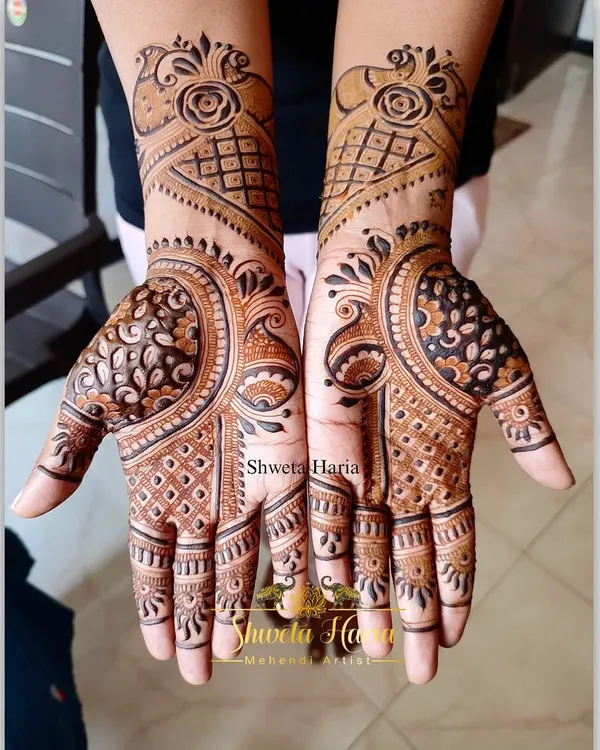 A beautiful floral mehendi design with a modern twist. This pattern combines rose motifs with geometric grids and bold peacock-inspired shapes for a unique and stylish look.