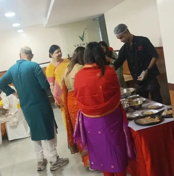 A chef interacting with guests while preparing fresh chaat at a live counter. This adds a personal and entertaining touch to any house party.