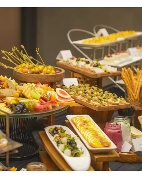 A symphony of flavours and textures. Our multi-tiered buffet setup features a wide variety of canapés, salads, and small plates, beautifully arranged for an evening soiree.