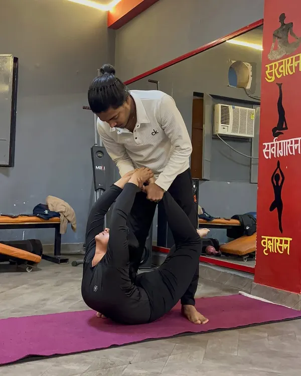 Here I am providing a hands-on adjustment in a deep backbend. This kind of support helps the student to relax into the stretch and safely deepen their flexibility.