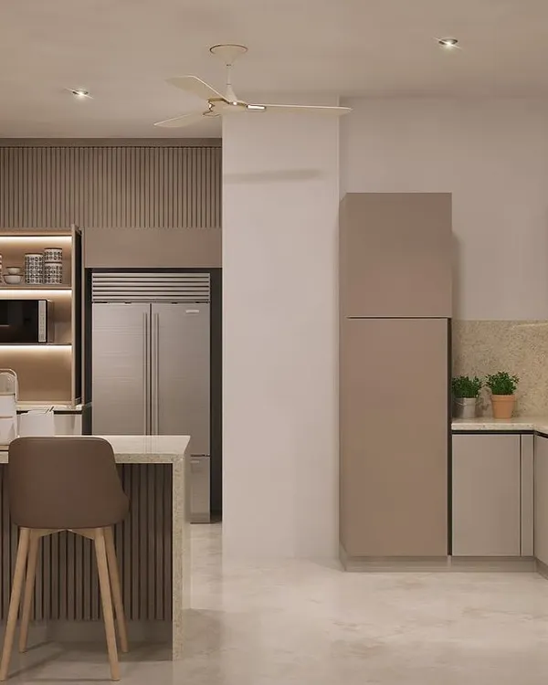 We design kitchens that are practical, functional, and beautiful. This view shows the layout of a modular kitchen with a breakfast counter, ample storage, and integrated appliances, all in a soothing neutral palette.