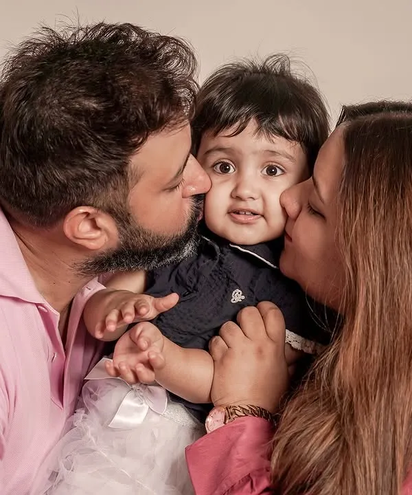 A beautiful, warm portrait of parents kissing their baby's cheeks. This is the kind of love and connection I aim to capture in every family photoshoot.
