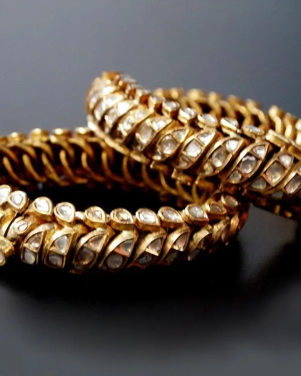 A pair of traditional 'Shrankhla Jodi' twisted bangles from Gwalior, circa 1820. These flexible bangles are crafted in 22-carat gold and set with diamond polkis, representing a rare piece of Maratha royal heritage.