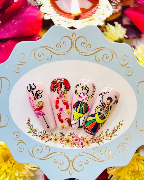 This hand-painted nail art set for Navratri features iconic motifs like the Goddess's eye, her footprints, and Garba dancers, showcasing the detailed character work we teach.