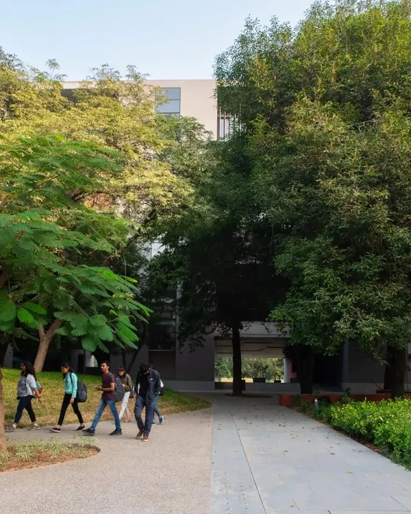 The campus of Ahmedabad University is designed as a seamless extension of its verdant landscape. Walkways and buildings are carefully sited among existing trees, creating a pedestrian-friendly environment that encourages movement and connection with nature.