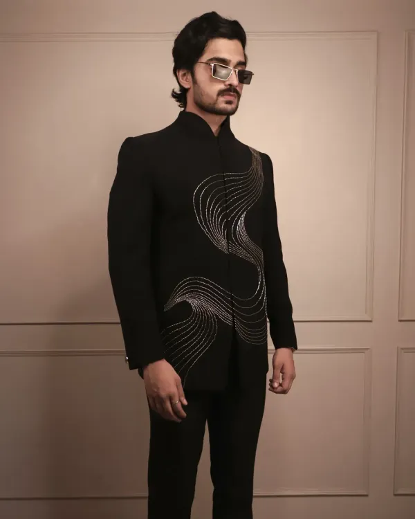 This is my 'Illusion Silver Lines' bandhgala, a piece designed for making a statement. The handcrafted silver embroidery flows across the sharp black fabric, creating a look that's perfect for a cocktail party or sangeet where you want to stand out with sophisticated style.